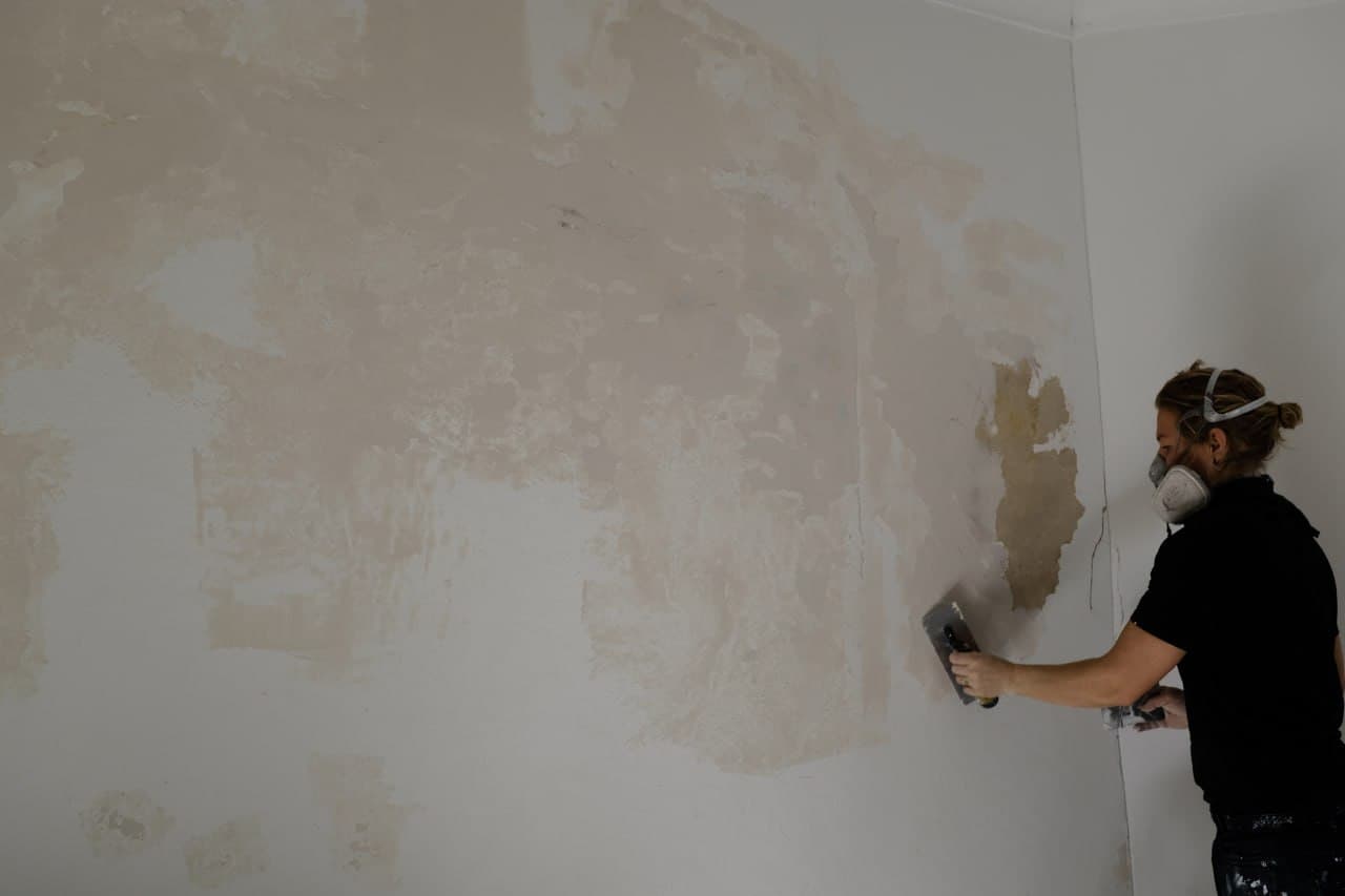 Painter preparing a wall surface — meticulous prep for a flawless finish